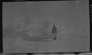 Image of Man standing by long canoe
